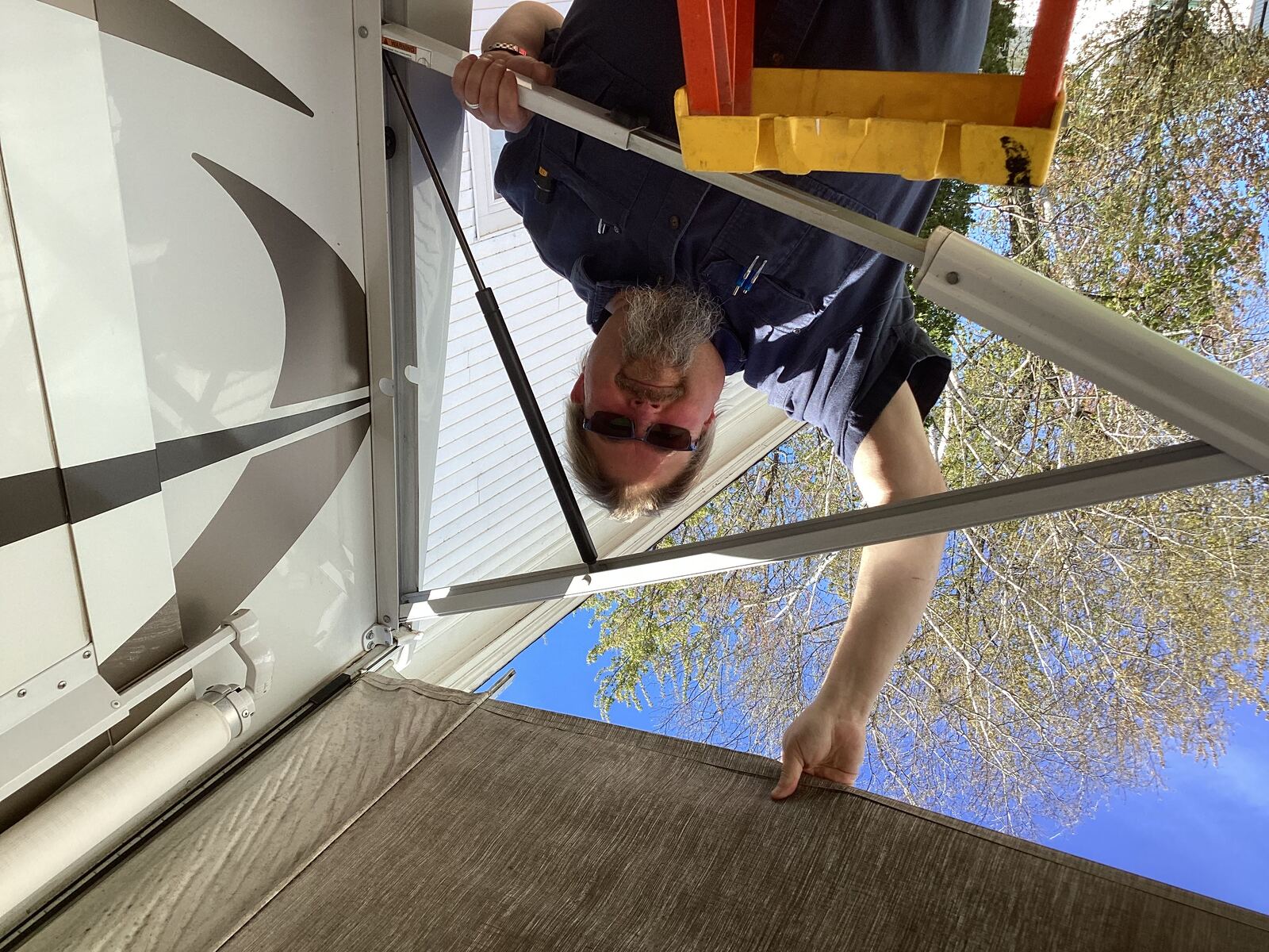 Steve replacing an RV awning on a ladder